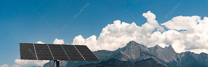 Large free-standing solar panel with panorama mountain landscape in the Swiss Alps