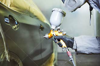 Repairman painter in chamber painting automobile car bonnet