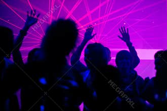 People dancing in club with laser