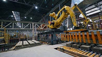 Working arm moves bricks on a line at a modern factory.