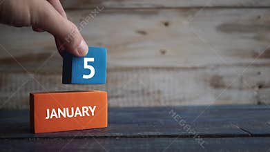 January 25th. Day 25 of month, calendar on a color cubes. hand puts the day of the month on the name of the month on a