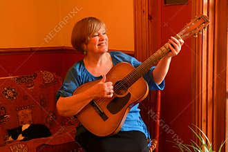 Happy senior guitarist, playing acoustic guitar.