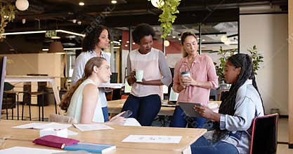 Diverse businesswomen having casual meeting, discussing work at office, in slow motion