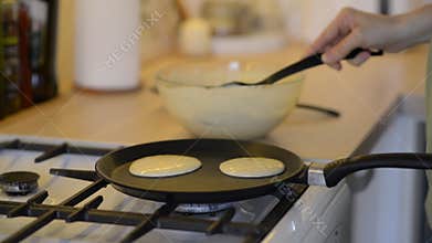 Closeup of cooking pancakes on a gas stove.