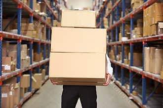 Man Carrying Boxes In Warehouse