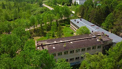The old sanatorium is located in a mountainous area with a dense forest.