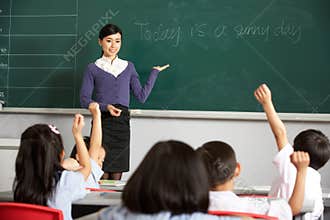Teacher By Blackboard In Chinese School