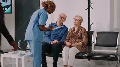 African american nurse talking to senior people in waiting room