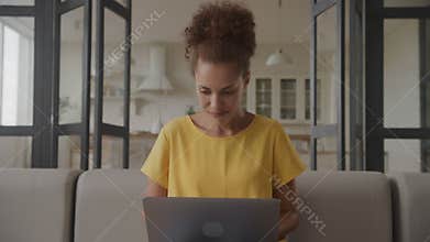 Woman in positive moment, aspiring news on laptop