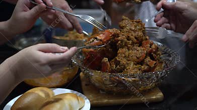 Family eating Singapore chilli crab home cook signature dish together with fried bread bun