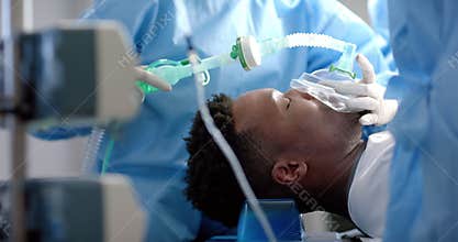 Diverse surgeons giving anesthesia to patient in operating theatre, slow motion