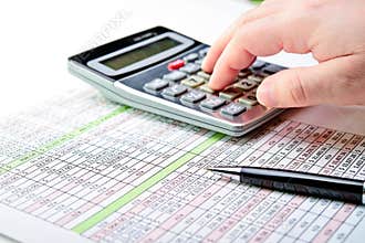 A spread sheet with pen and calculator.