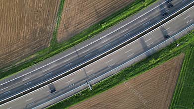 Birdeye footage of cars driving on the Autobahn 5 highway by green fields in Butzbach, Germany