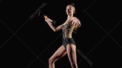 Female athlete performing variety of rhythmic gymnastic elements with clubs