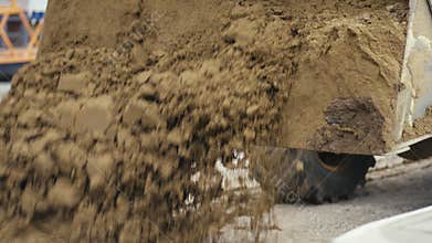 Heavy Machinery at Work An Excavator Efficiently Dumping Dirt on a Busy Construction Site