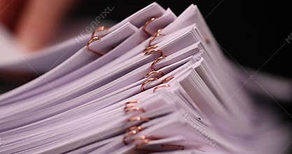 white blank sheets of paper connected by copper staples