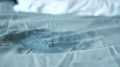 A visible stain on a light blue bedsheet