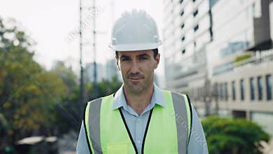 Portrait of smiling caucasian man engineer against highrise building