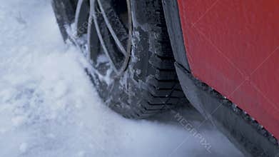 Red car with snowy tyres