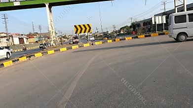 Vehicle Making U-Turn on Busy Road with Pillar Bridge Visible Ahead,