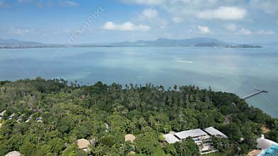 Drone shot of luxury resorts on a Thai island with sandy beaches and waves