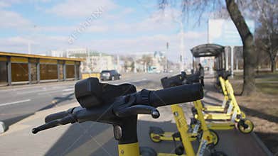 Bright Yellow Electric Scooters Conveniently Parked on a Busy City Street for Everyone to Use