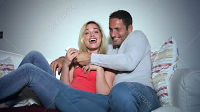 Young Couple On Sofa Watching TV Together