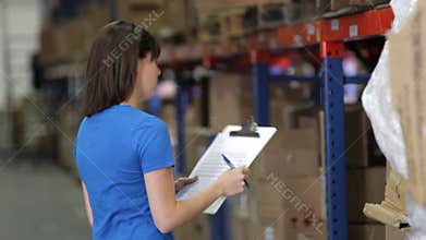 Female Worker With Clipboard In Warehouse