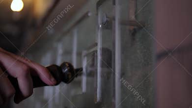 Close-up of a man driving a magnet along a glass wall with a maze. Quest.