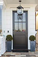 Black front door framed by plants