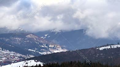 Clouds moving over snowy mountain range