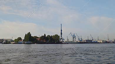 Sailing barge and tower cranes in urban industrial port in Hamburg city Germany