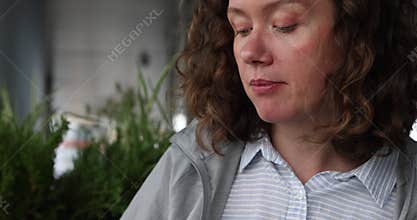 Contemplative woman engaging delicious snack in lively urban setting, surrounded by natures beauty