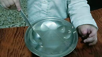 Baby playing with spoon and plate