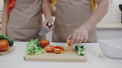 A couple is enjoying the experience of cooking together in a beautifully modern kitchen while surrounded by an array of