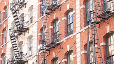 New York City building architecture, Manhattan. Residential house exterior. Red brick, fire escape.