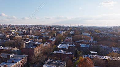 Aerial view capturing New York City borough in Brooklyn, autumn foliage draping residential streets and cityscape with