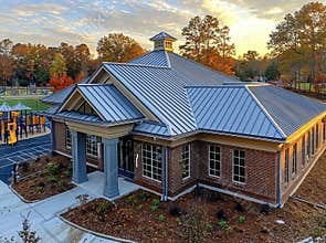 Drone images taken during the day showing a commercial standing seam metal roof of an elementary school