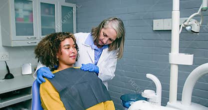 Dentist Prepares Young Black Woman With Afro for Checkup in Modern Dental Office