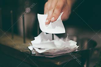 Hand putting restaurant order ticket on stick