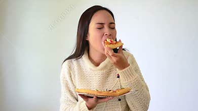 Asian girl shows and eating seafood pizza