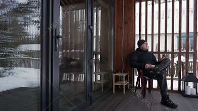 A man drinks coffee on the terrace of a house.