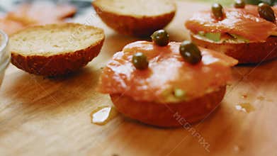 Marinated capers added as a topping to a smoked salmon sandwich