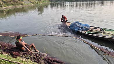 Fishermen Gathering Net And Tying Knot On Wooden Boat In Pond