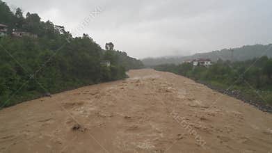 Muddy river in Bangladesh flows fast after rain with brown water, foam tropical flood conditions, dangerous, monsoon, soil, stream