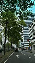 Urban street corridor with forward arrow, lined by leafy trees and modern