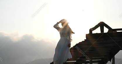 Asian woman in white outfit walking on wooden bridge at sunset seaside ocean golden light travel scene