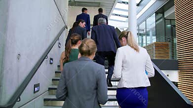 Businesspeople interacting with each other while walking on stairs
