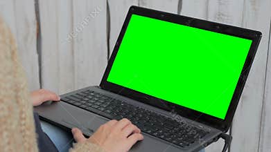 Woman using laptop with green screen