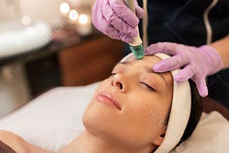Woman having microdermabrasion facial treatment